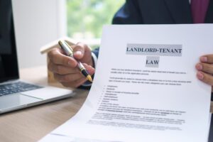 the hand of a man holding a house purchase contract with a pen showing up to customers