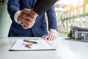 shake hand real estate brokerage agent deliver a sample of a model house to the customer