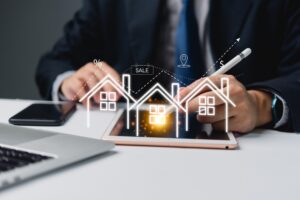 Businessman using tablet with holographic real estate icons