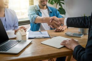 Hand shake between sale representative and house owner when sign contact of home purchase